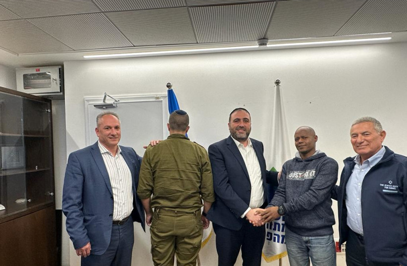 Interior Minister Moshe Arbel (third from left) shakes hands with Molugata Tsagai, to his right, who saved the life of Lt. Col Y, on Arbel's left, during Hamas's October 7 attack, November 26, 2023. (credit: COURTESY INTERIOR MINISTRY)